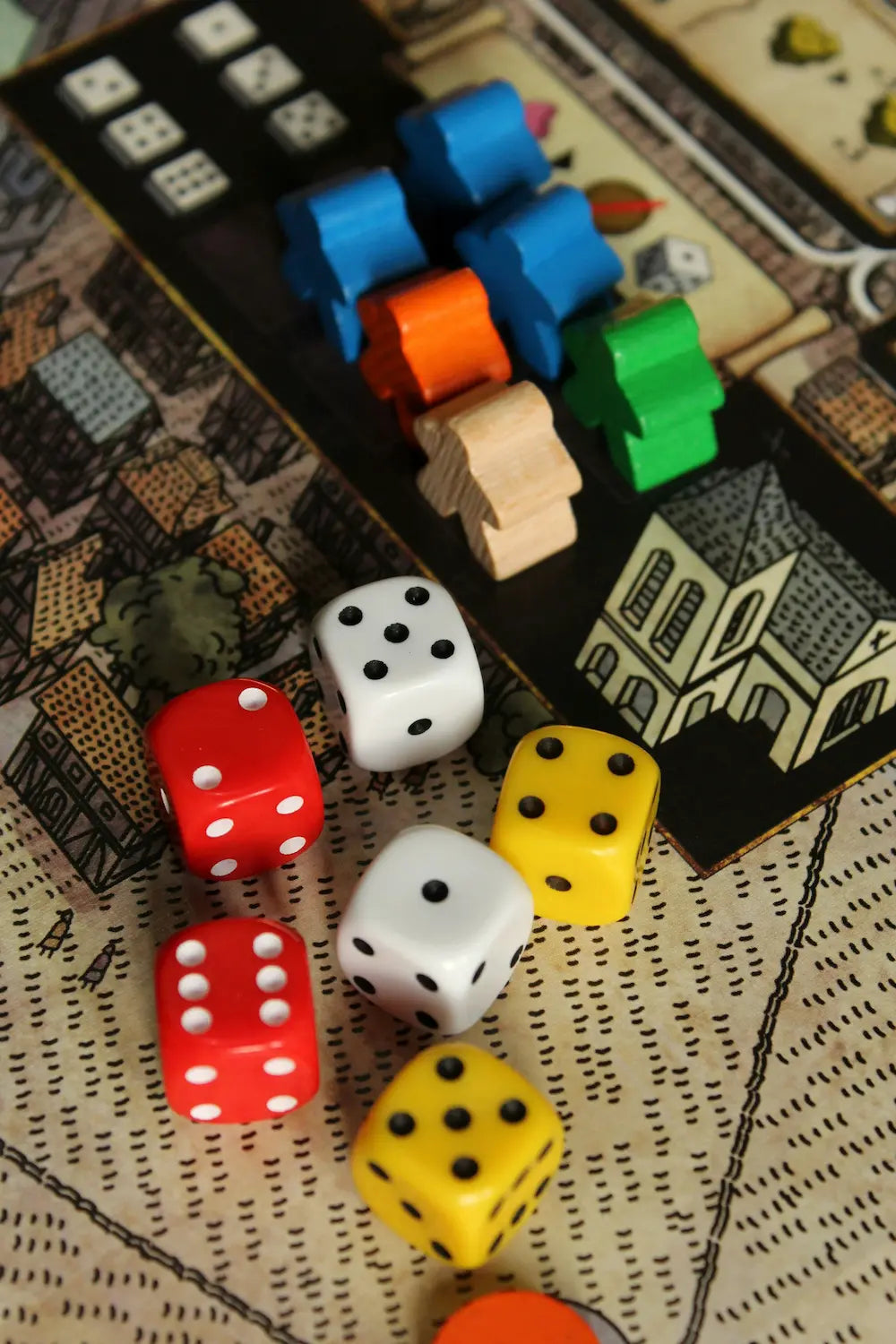 Colorful dice and game pieces on a board game surface